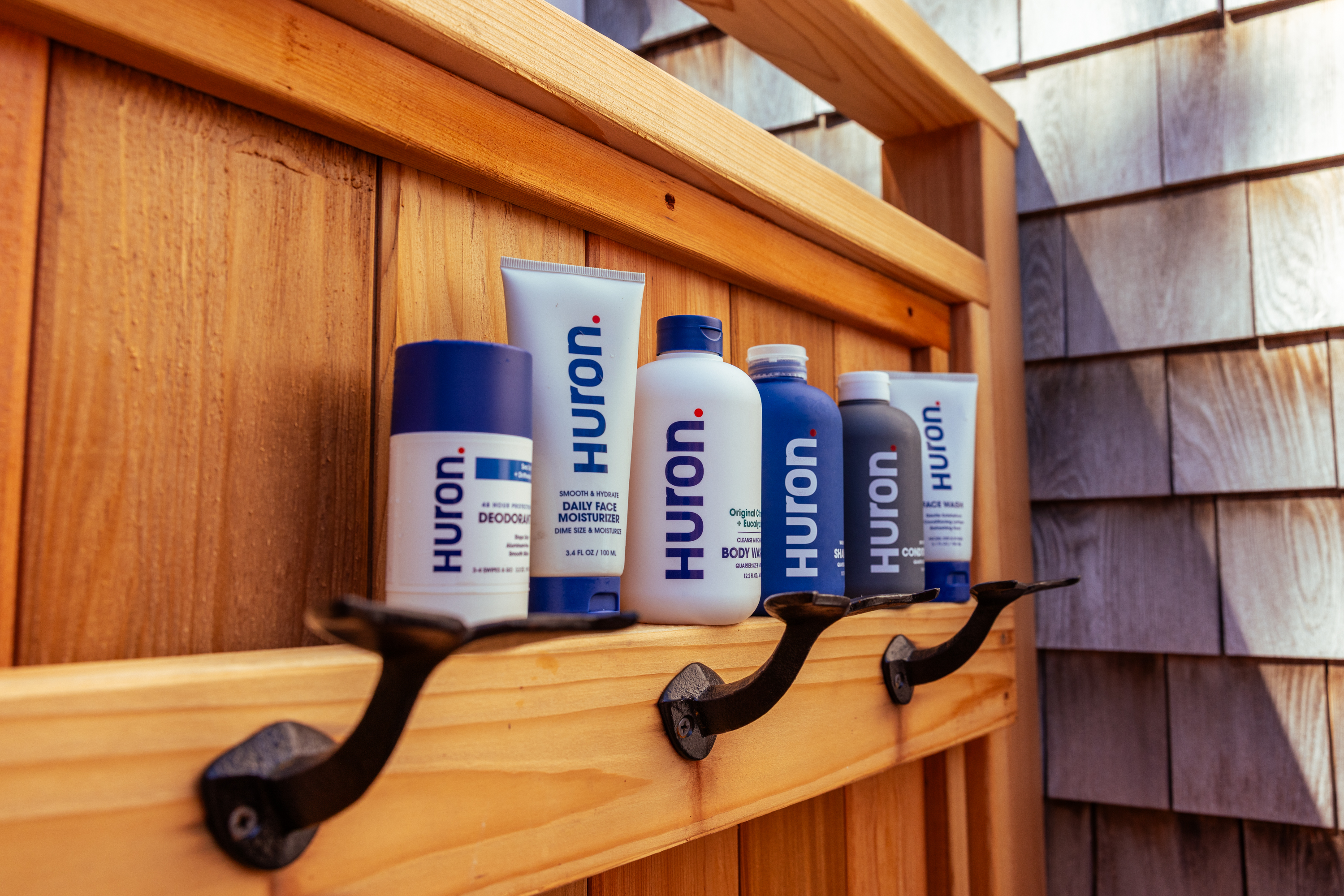 Minimalist workspace with stationery, plant, lamp, lotion bottles, and a takeout box.