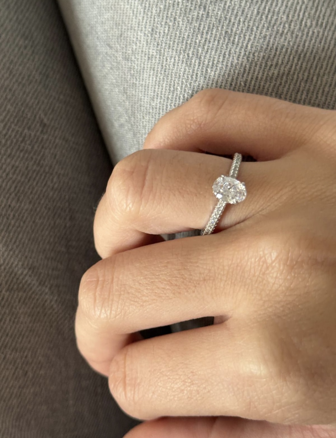 Hand wearing a diamond ring on the ring finger.