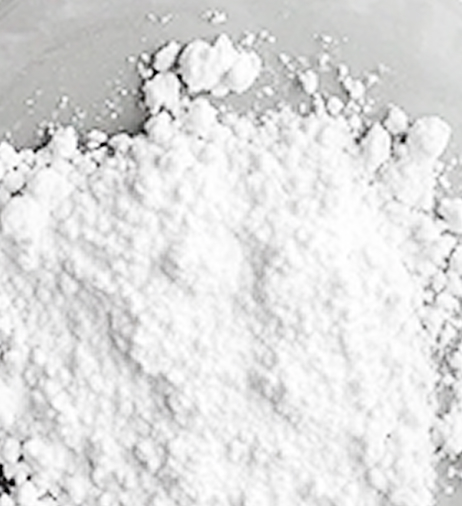 A close-up shot of a pile of fine white powder on a light gray surface.