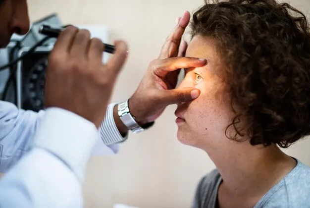 Doctor examining a patient's eye with a light.