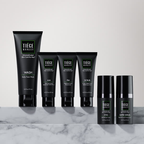 Tiege Hanley skincare products displayed on a marble surface.