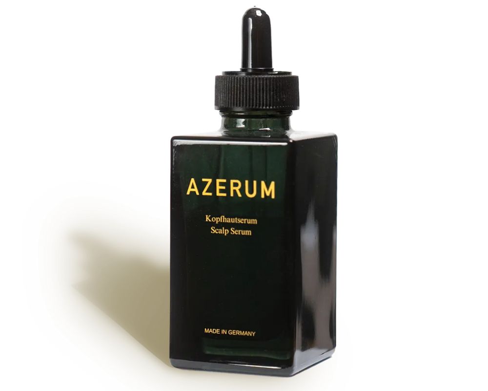A dark green, square bottle of Azerum scalp serum with a black dropper on a white background.
