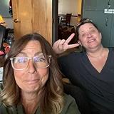 A selfie of two smiling women, one of whom is making a peace sign.