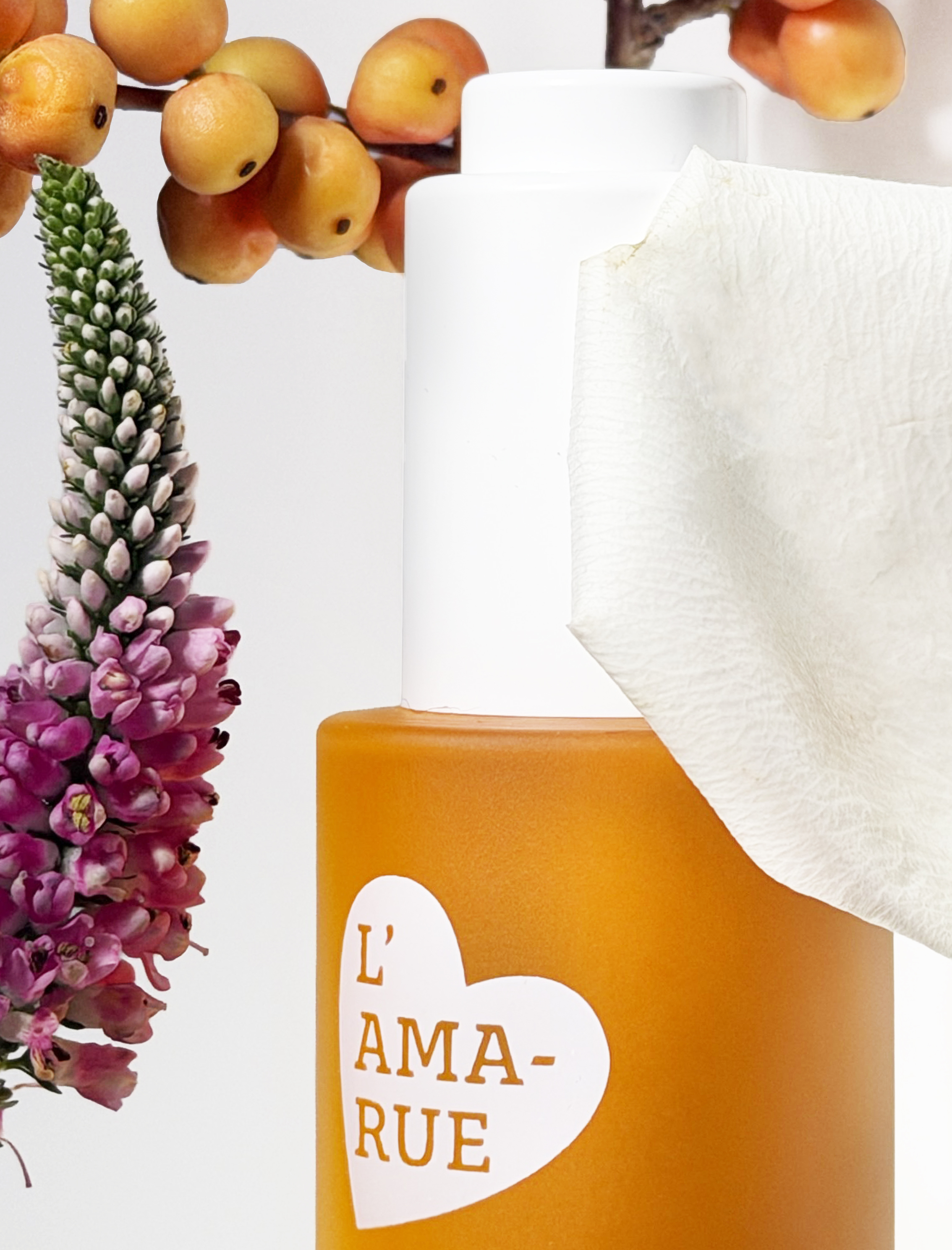 Orange bottle labeled 'L'Ama-Rue' with flowers and a cream-colored texture.