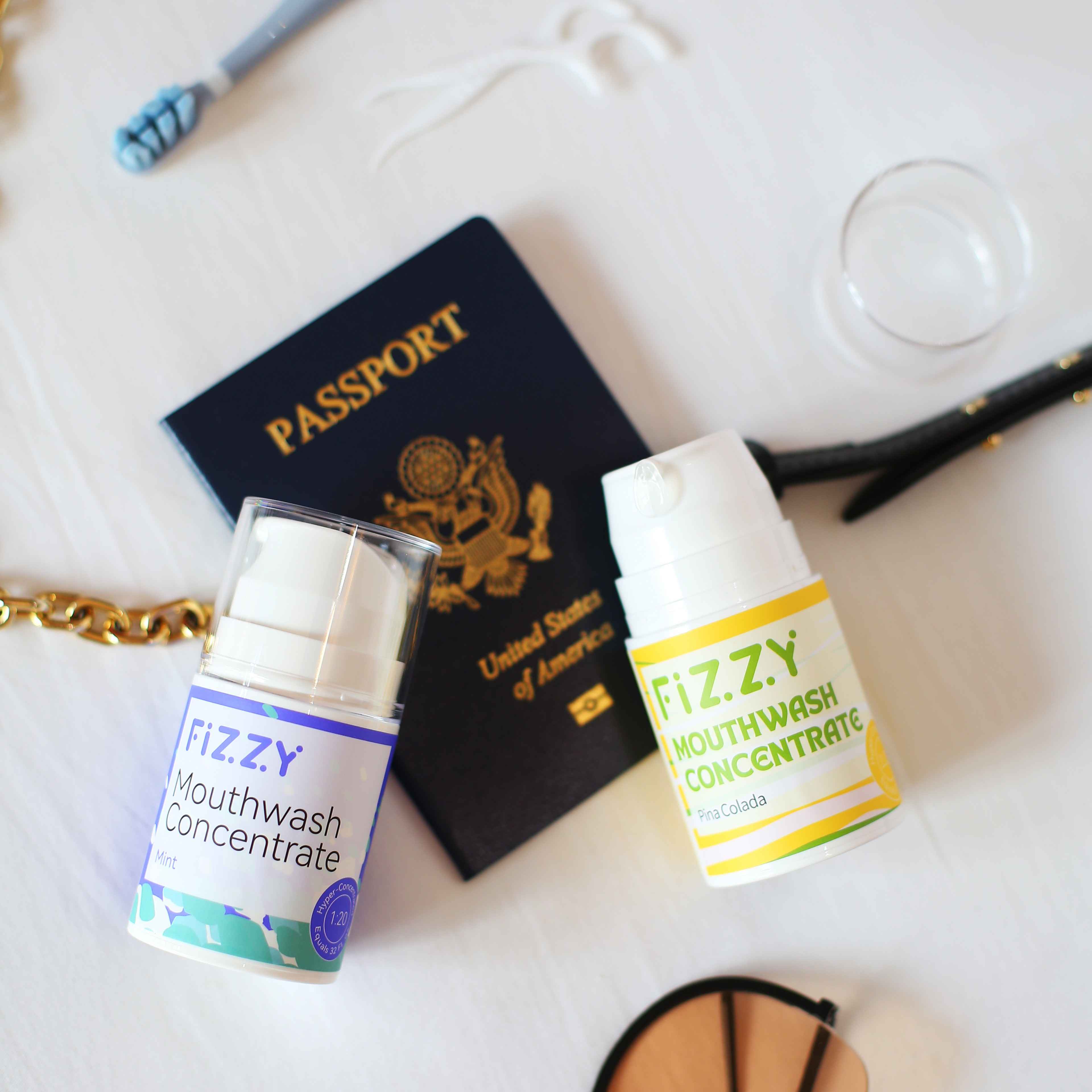 Passport with two bottles of mouthwash concentrate on a white surface.
