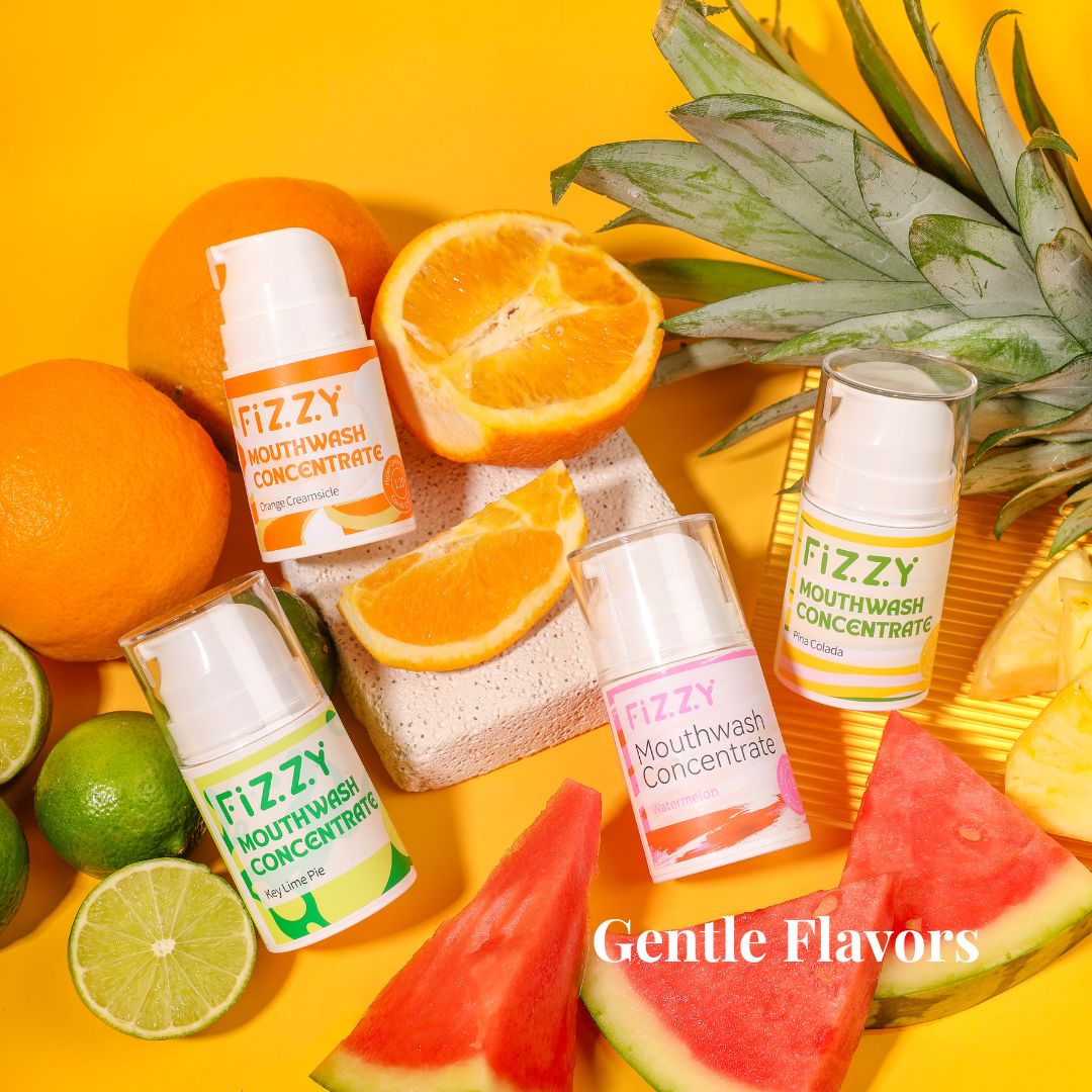 Four flavored mouthwash bottles with fruits on a yellow background.