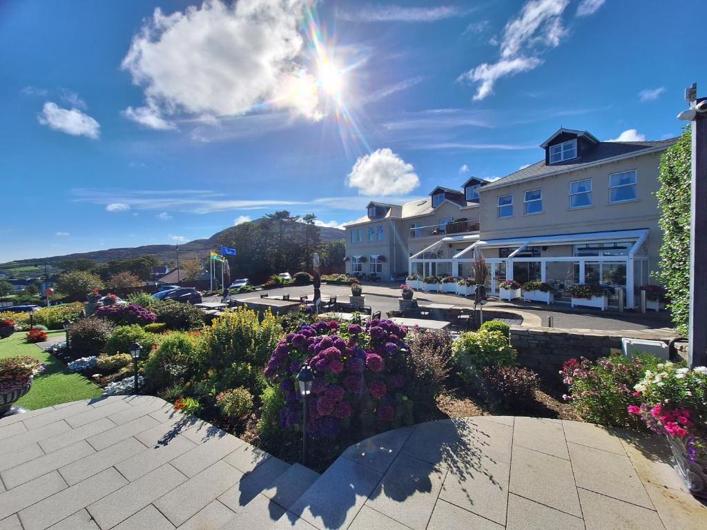 Sunny day at a hotel with gardens and mountains in the background.