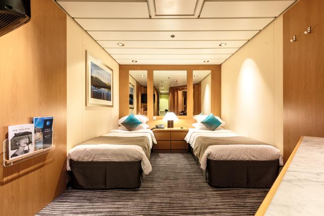 Interior of a cabin with two single beds and a mirror.