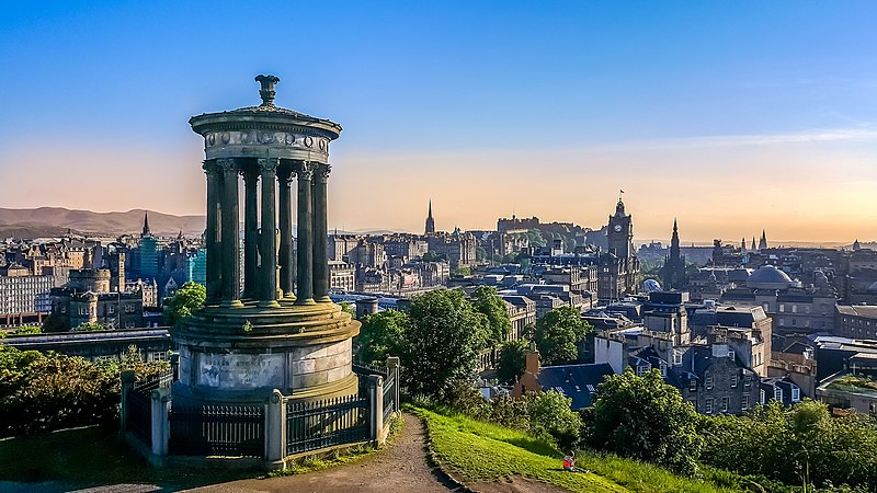 View of a cityscape with a neoclassical monument in the foreground.