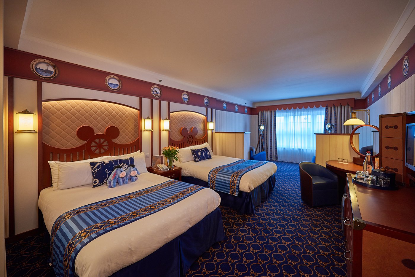 Hotel room with a double bed, sofa, and western-themed decor.