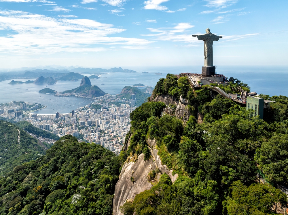 The Christ the Redeemer statue stands atop a mountain, overlooking the city and bay of Rio de Janeiro.
