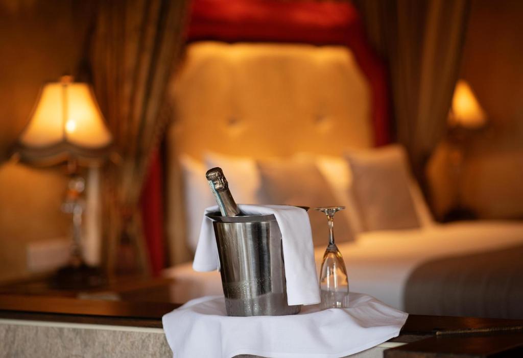 Champagne in an ice bucket with a glass in a luxurious bedroom setting.