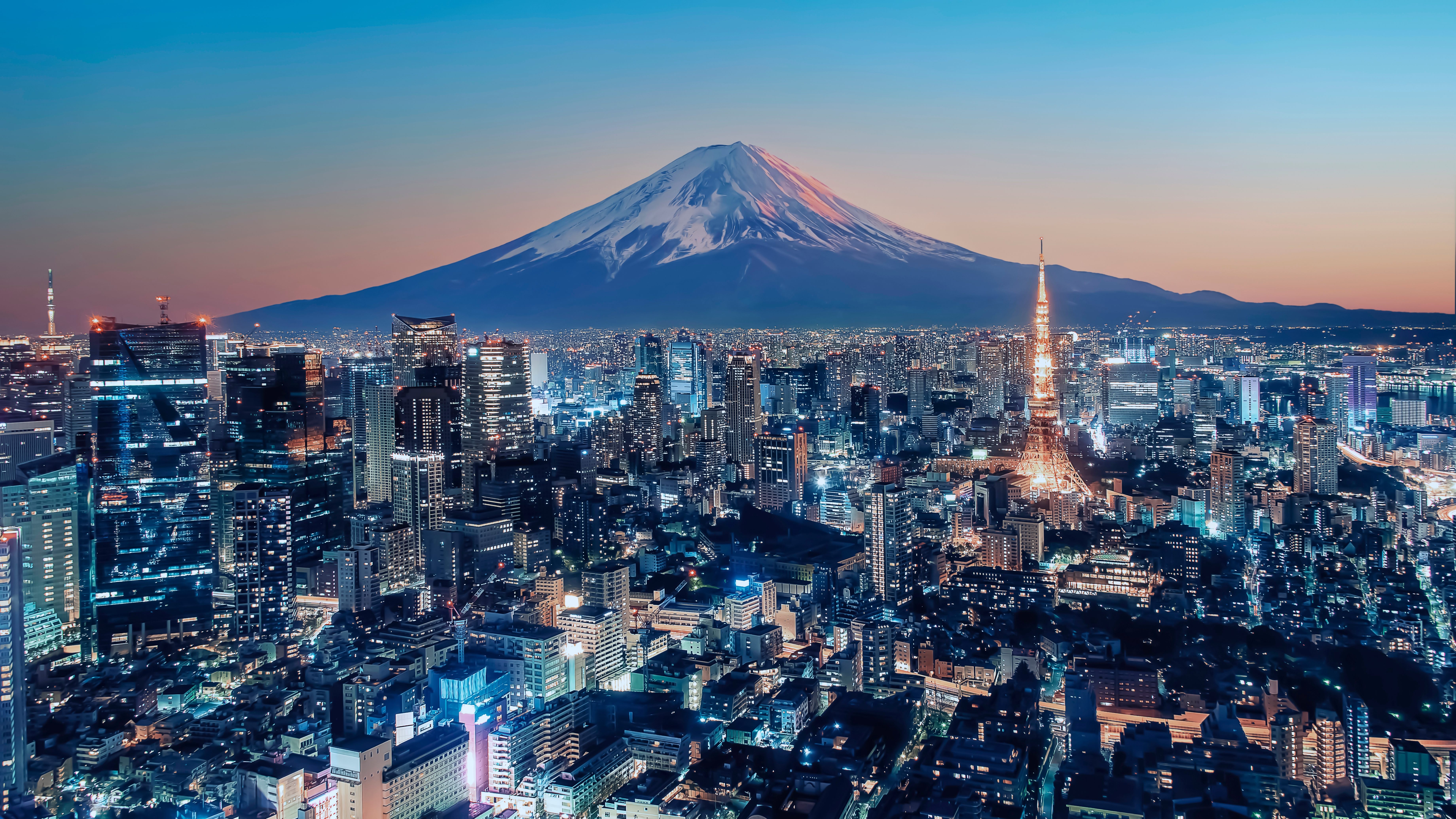 City skyline at dusk with a mountain in the background.