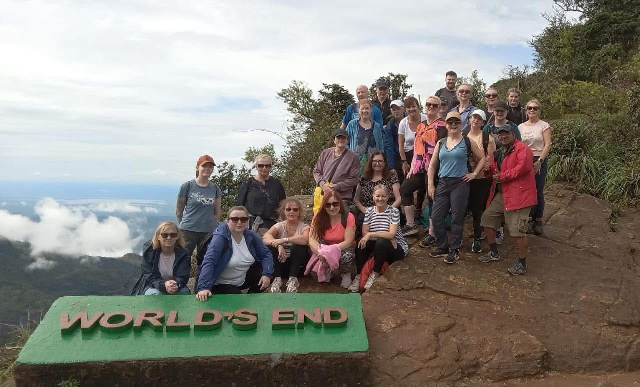 Group of people posing at World's End viewpoint with scenic background.