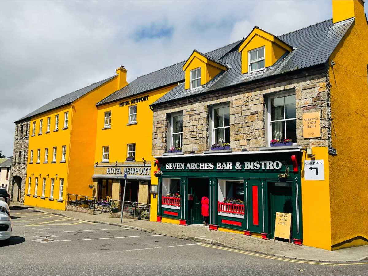 Colorful buildings with 'Hotel Newport' and 'Seven Arches Bar & Bistro' signs.