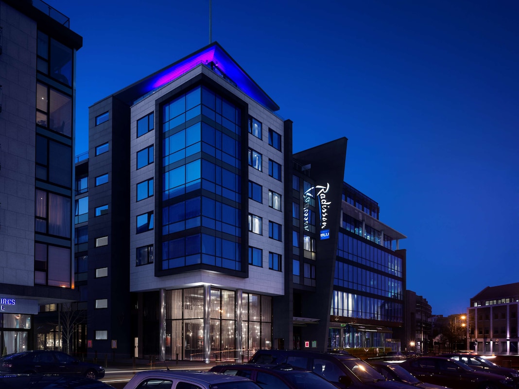 Modern hotel building with blue lighting at night.