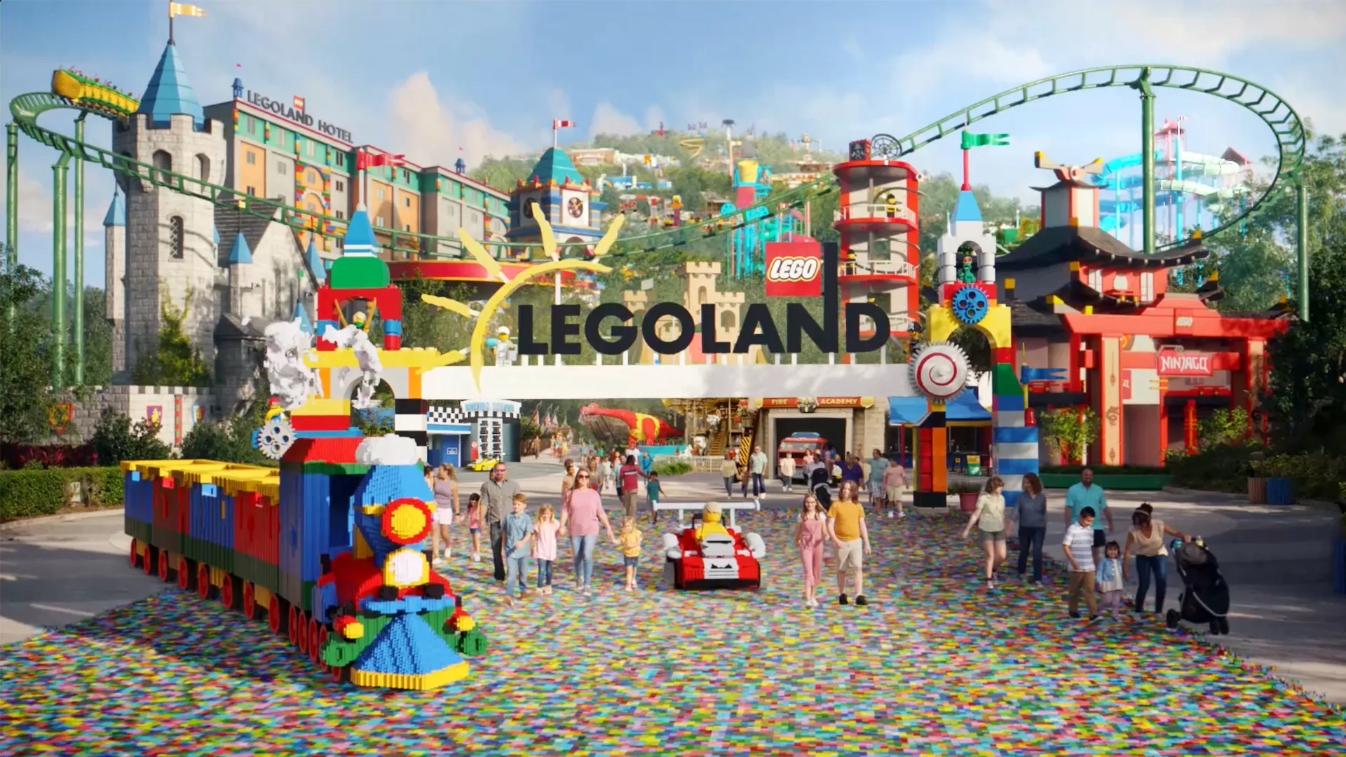 Colorful LEGO-themed amusement park entrance with families and a roller coaster.