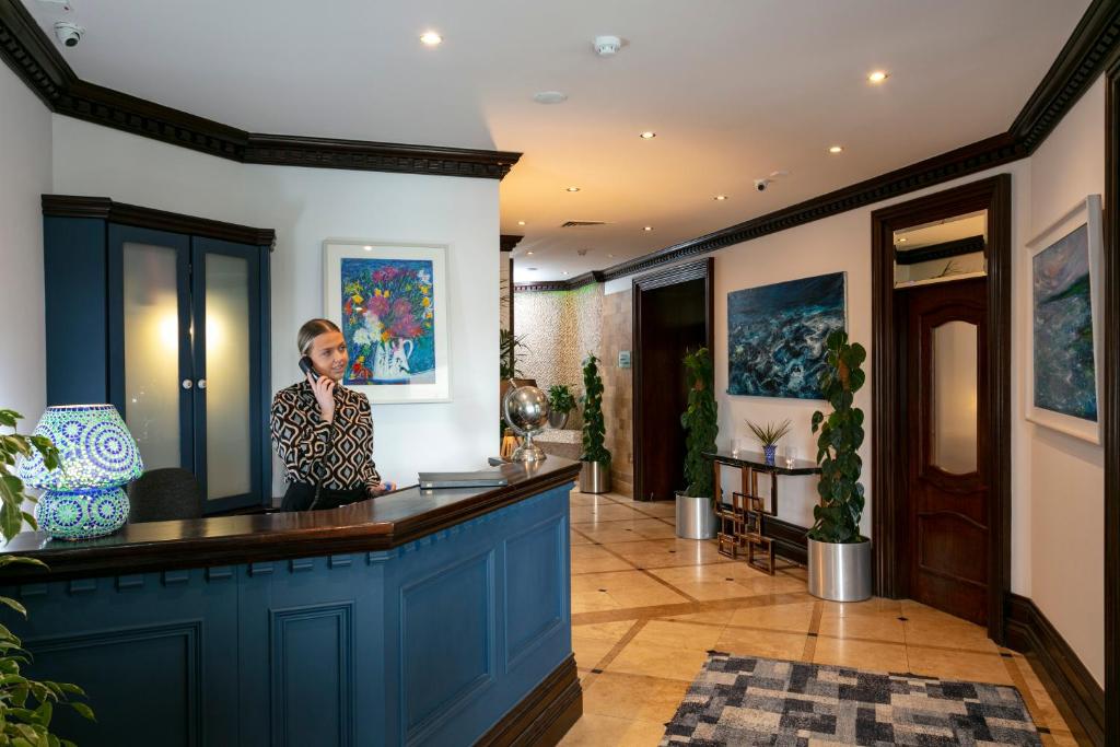 Reception area with a person on the phone, artwork, and plants.