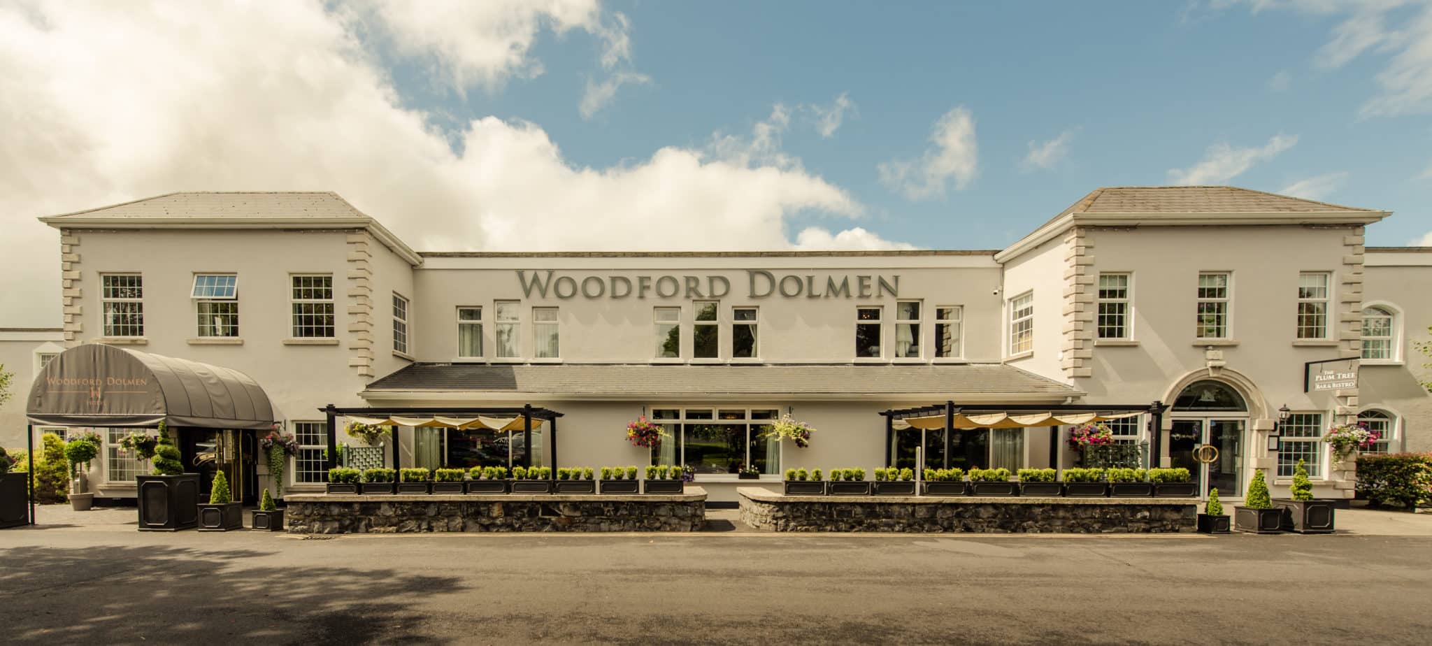 Front view of a large building with 'Woodford Dolmen' sign.