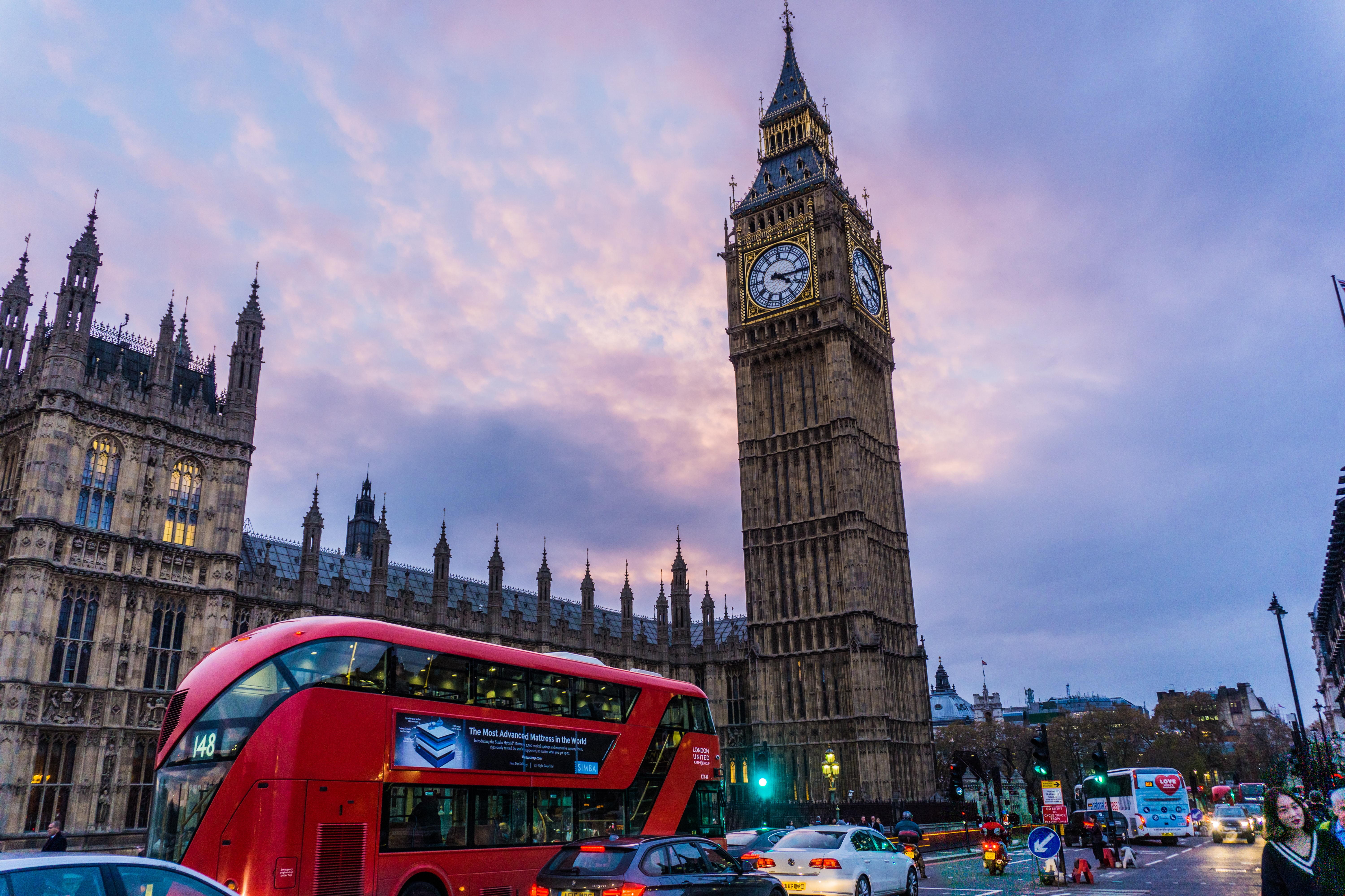 Big Ben and red double-decker bus in London at sunset.