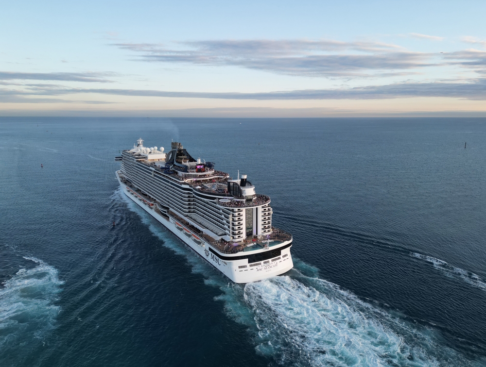 An aerial view of the large MSC Seascape cruise ship sailing on the open ocean at dusk.