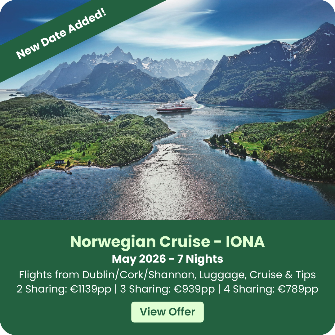 Cruise ship sailing through a scenic fjord with mountains and lush greenery.