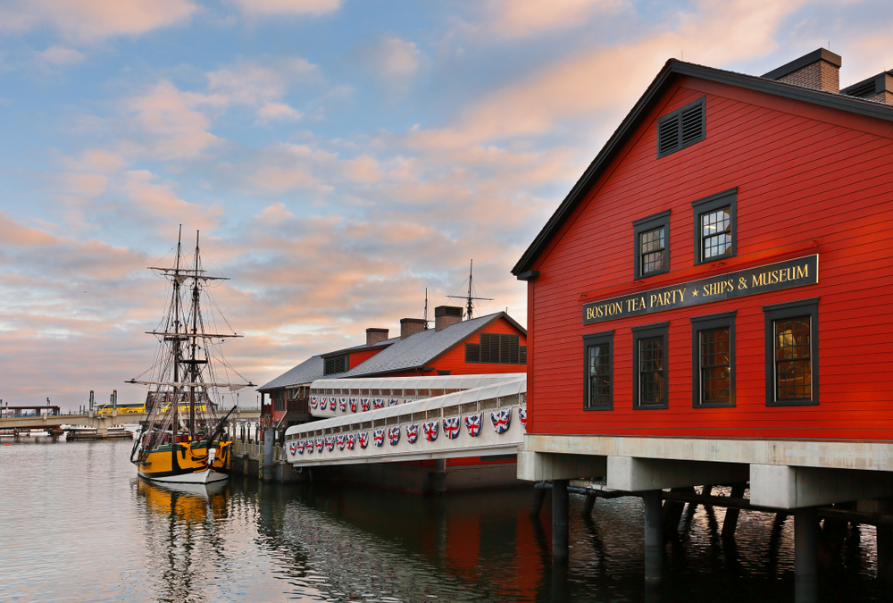 The Boston Tea Party Ships & Museum, a red building on the water with a historic ship docked.