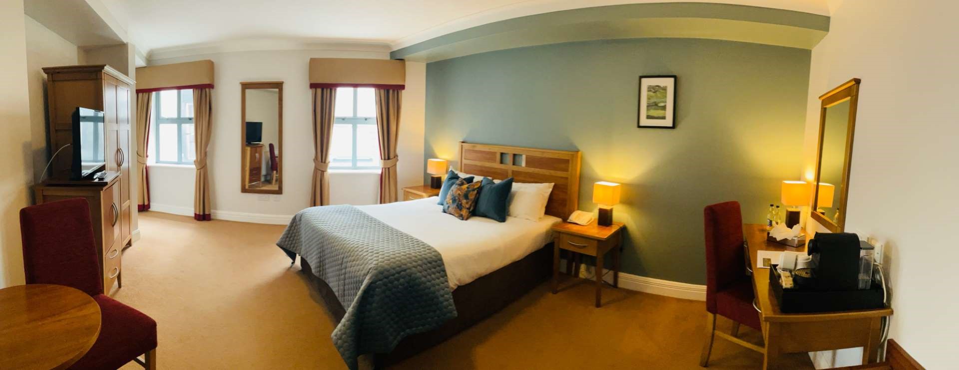 Cozy hotel room with a double bed, desk, and window.