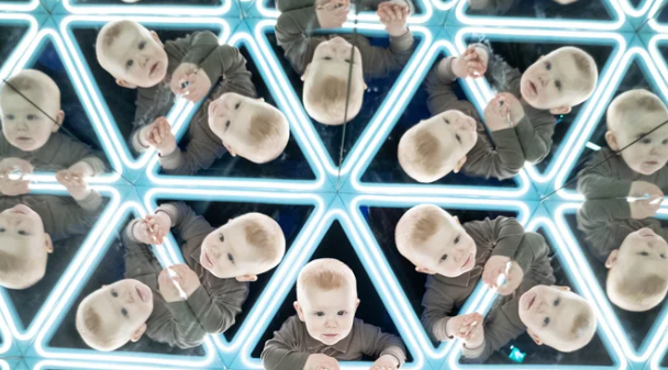 A baby reflected multiple times in a mirrored geometric pattern.
