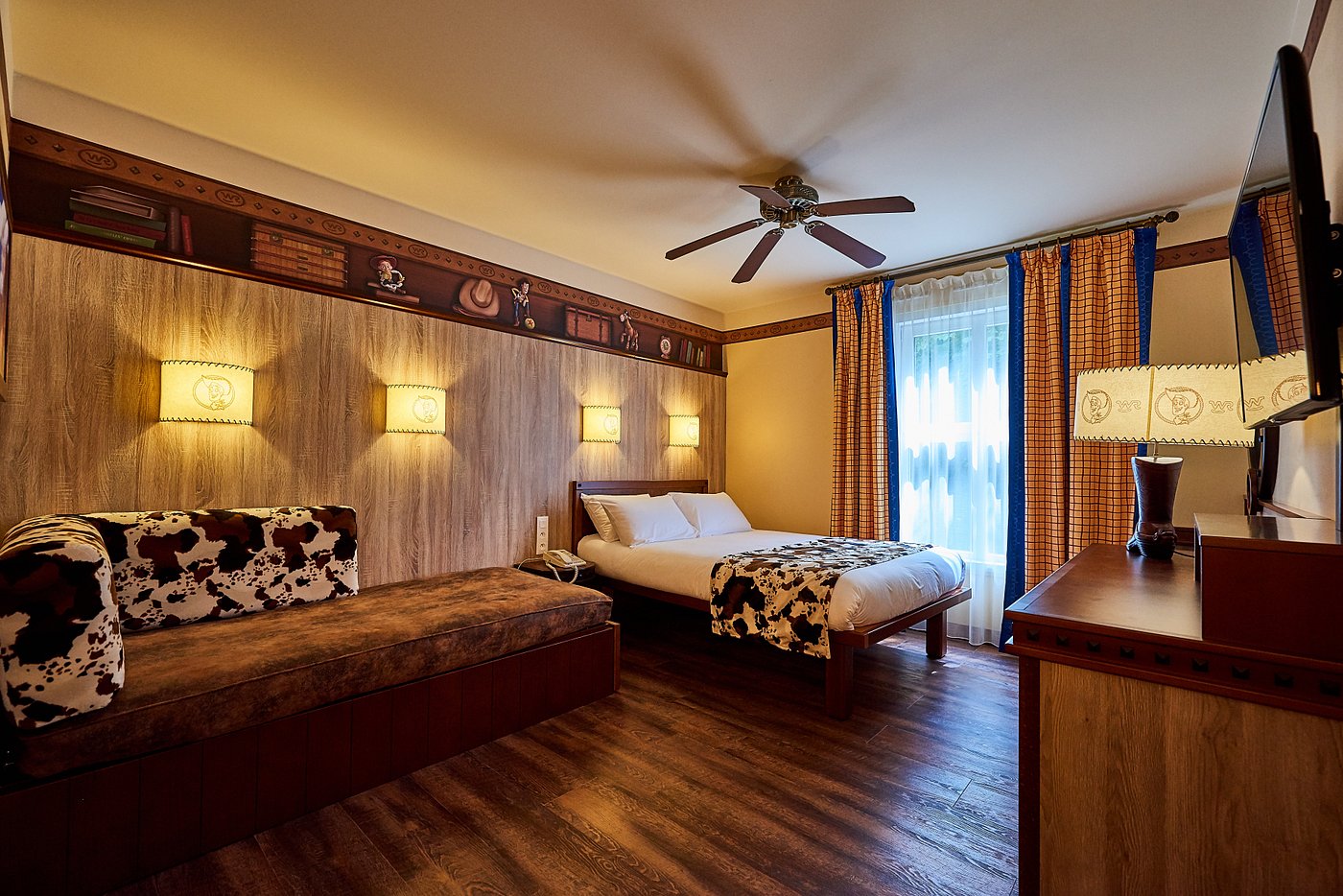 Hotel room with a double bed, sofa, and western-themed decor.