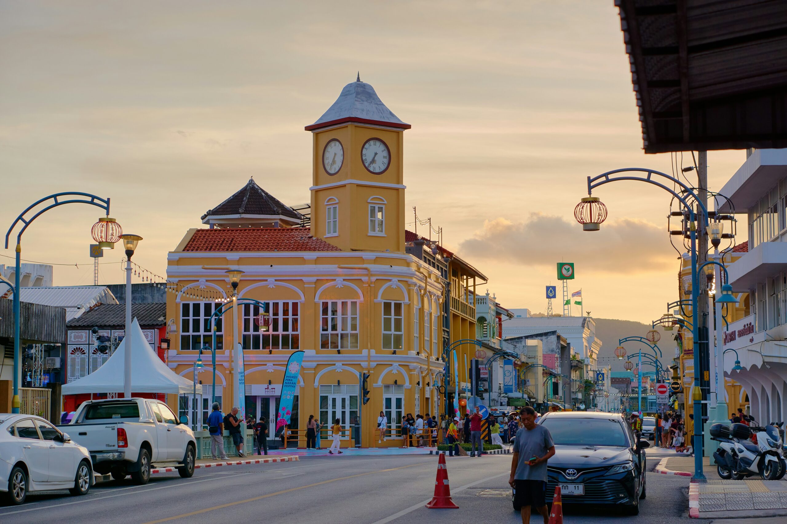 Street scene with a yellow clock tower building at sunset.