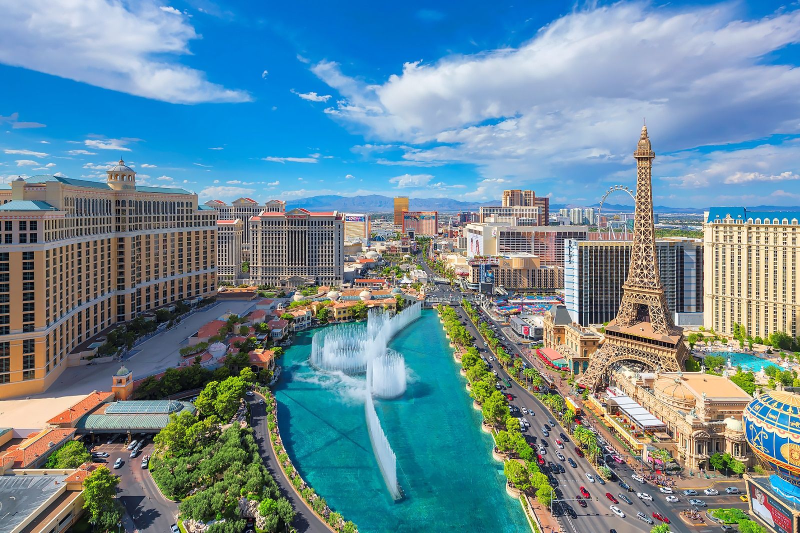 An aerial view of the Las Vegas Strip, featuring the Bellagio fountains and the Paris Las Vegas hotel.