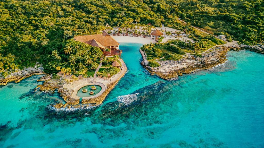 Aerial view of a tropical resort with lush greenery and turquoise waters.