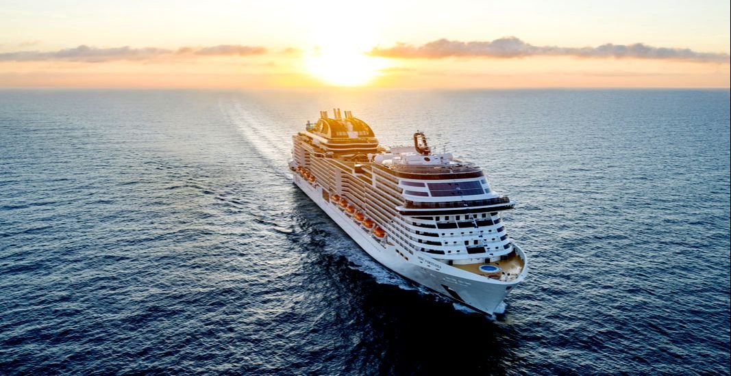 Cruise ship sailing on the ocean at sunset.