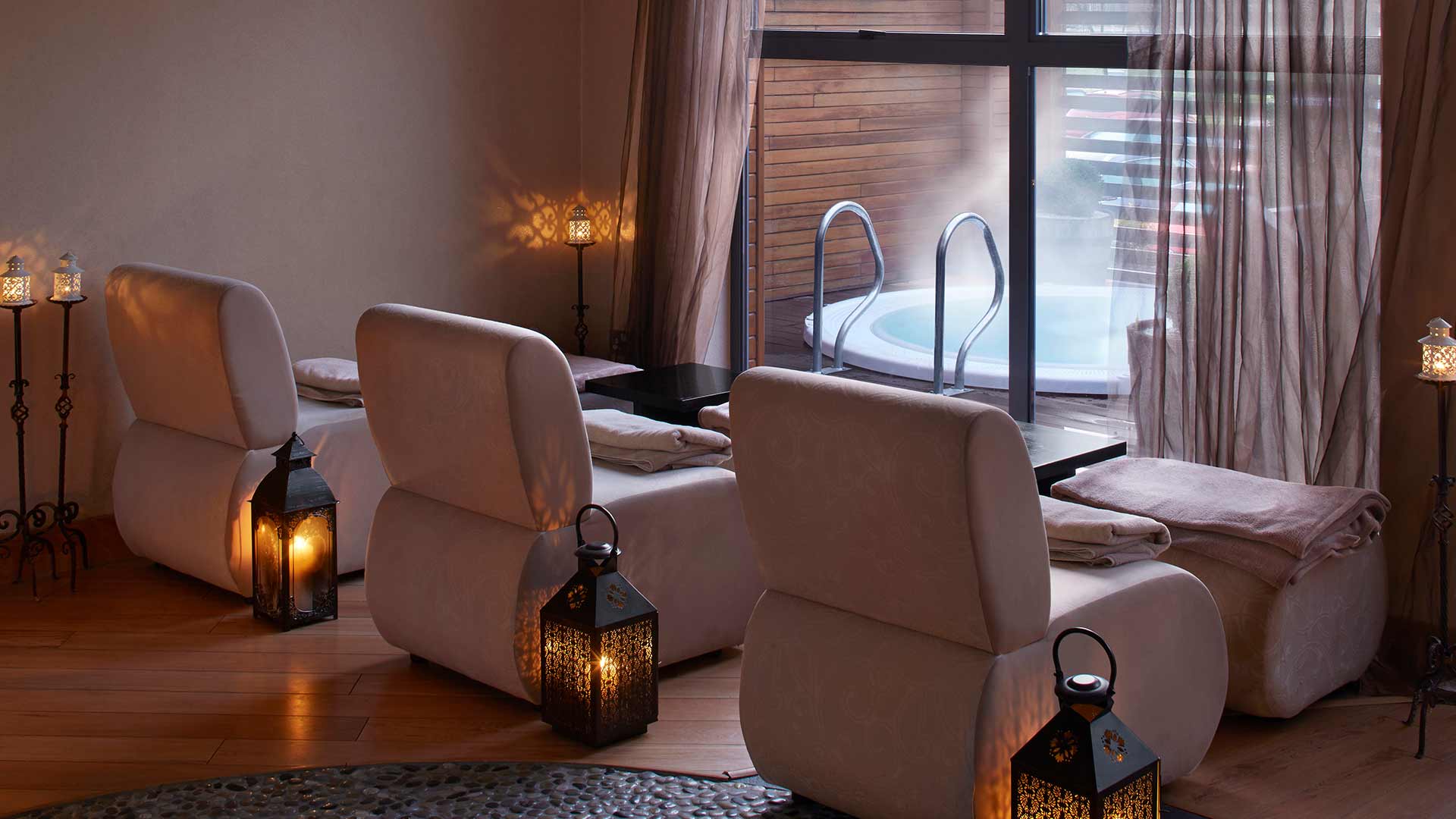 Modern hotel room with a large bed, lamps, and a window view.