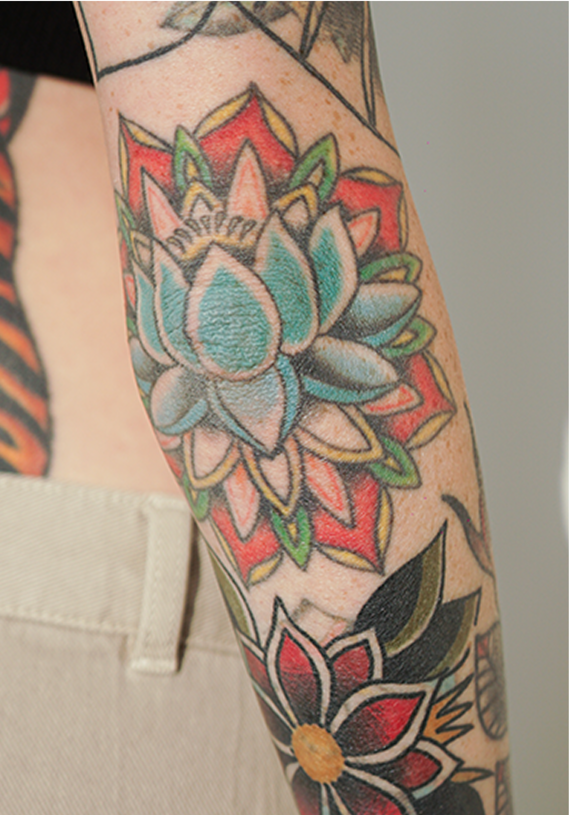 Arm tattoo featuring colorful floral designs.