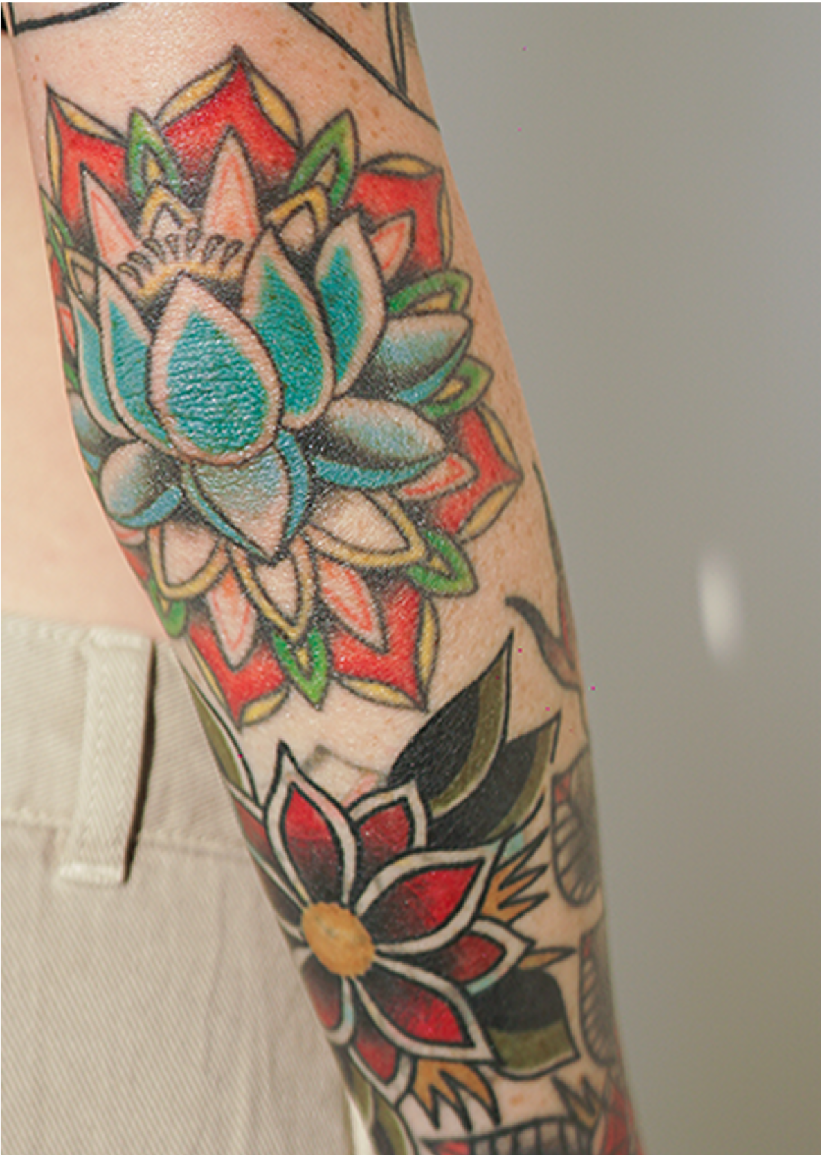 Colorful floral tattoos on an arm.