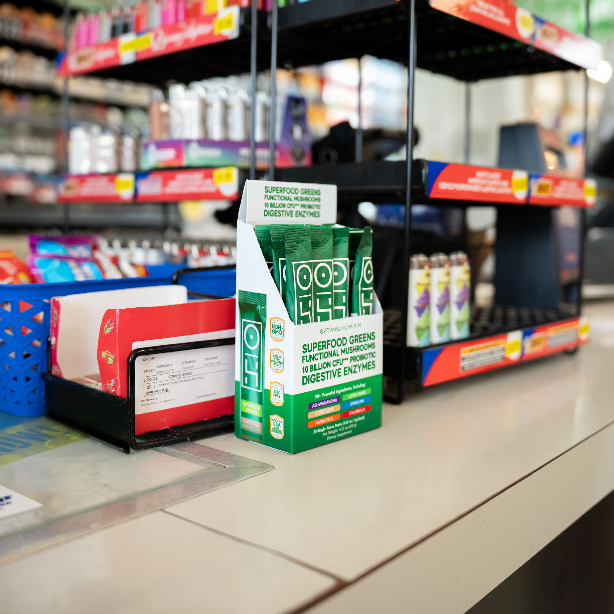 Superfood greens supplement display on a store counter with shelves in the background.