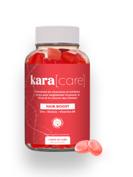 A bottle of Kara[care] Hair Boost gummies, with two red heart-shaped gummies sitting next to the bottle.