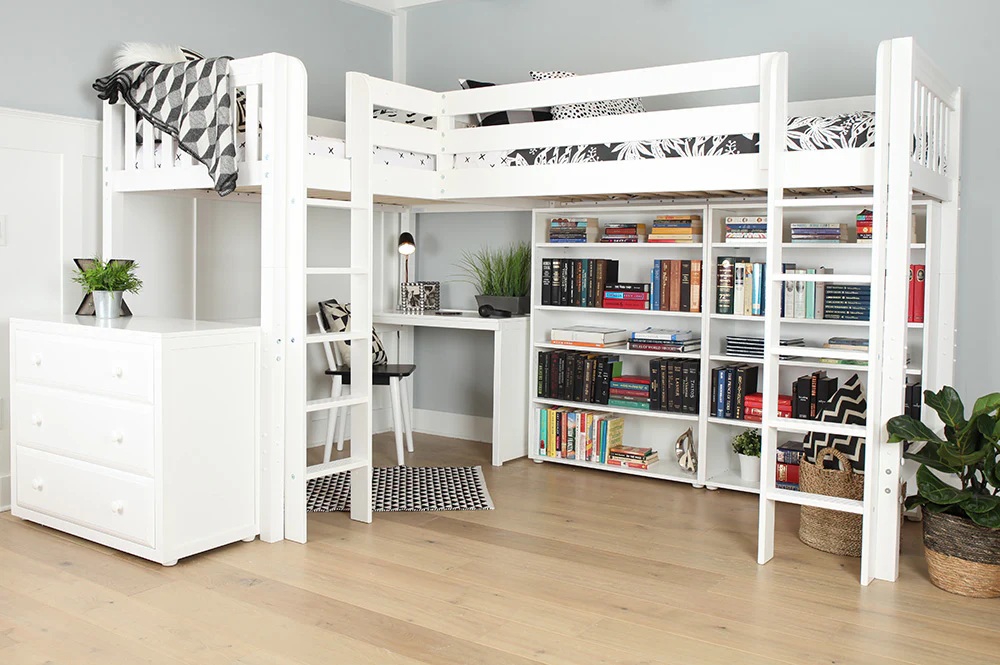 An L-shaped double loft bed with a desk, dresser, and bookcases underneath, decorated with black and white decor and potted plants.