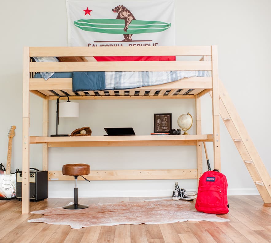 Loft bed with desk in a modern teen bedroom featuring a California Republic flag, guitar, and red backpack.