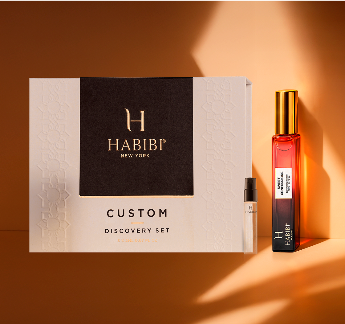 Perfume discovery set with two bottles: one transparent, one amber, on an orange background.