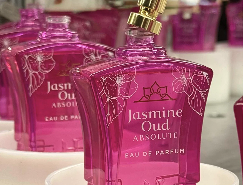 Pink perfume bottles labeled 'Jasmine Oud Absolute' with floral designs.