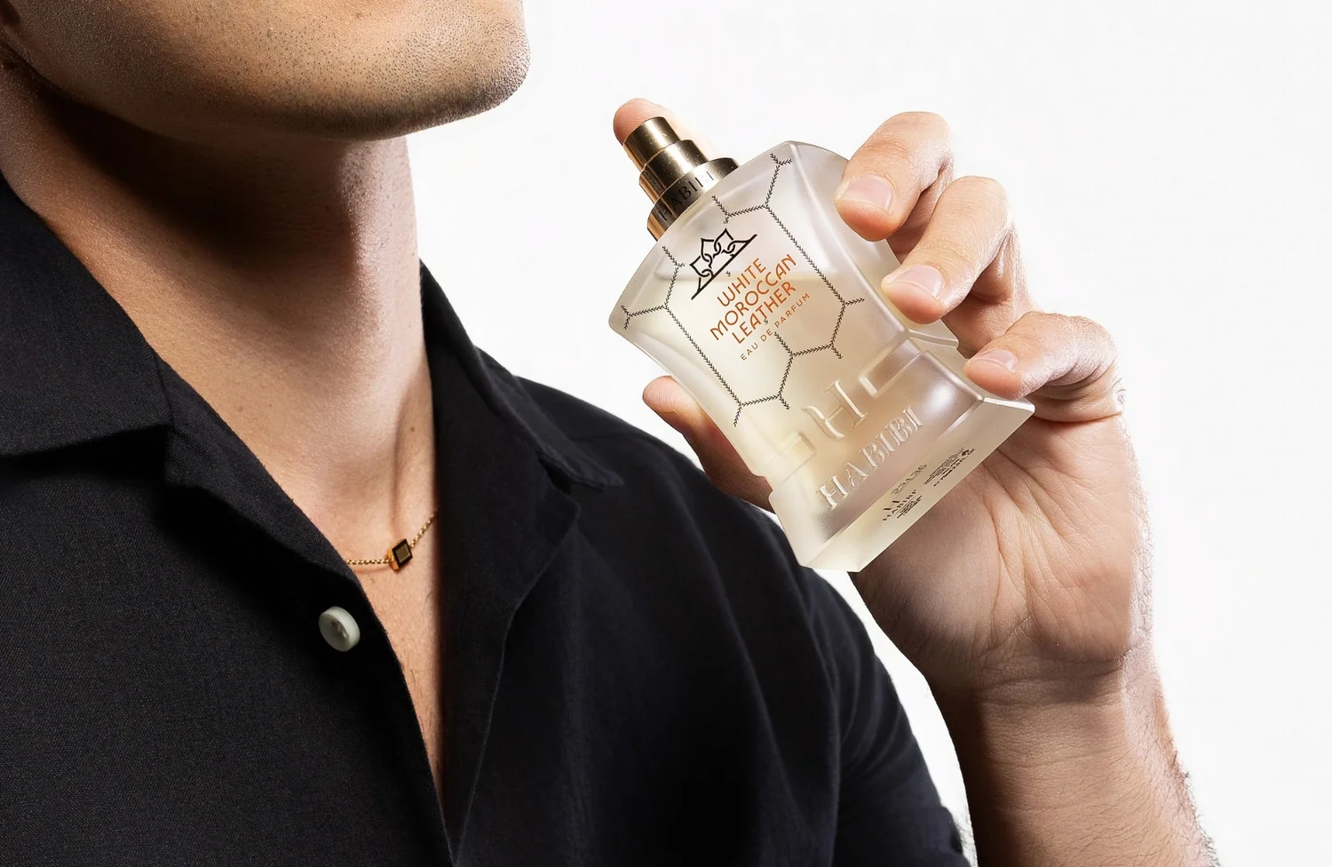 Person holding a bottle of White Moroccan Leather perfume.