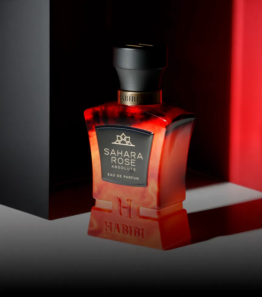 A red and black perfume bottle labeled 'Sahara Rose Absolute' by Habibi.