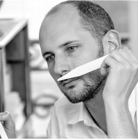 Man smelling a scent strip thoughtfully.