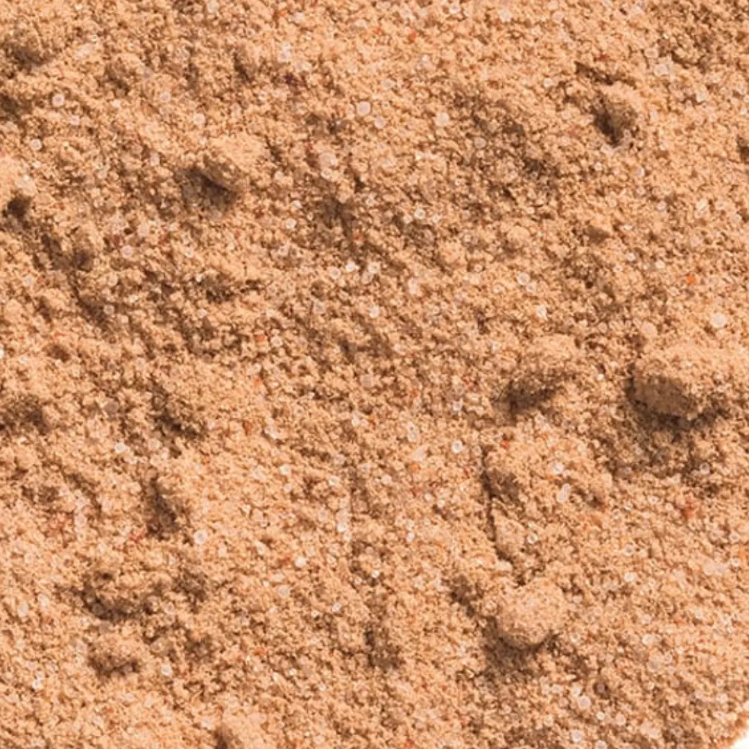 Close-up of brown, fine-grained sand with small pebbles.