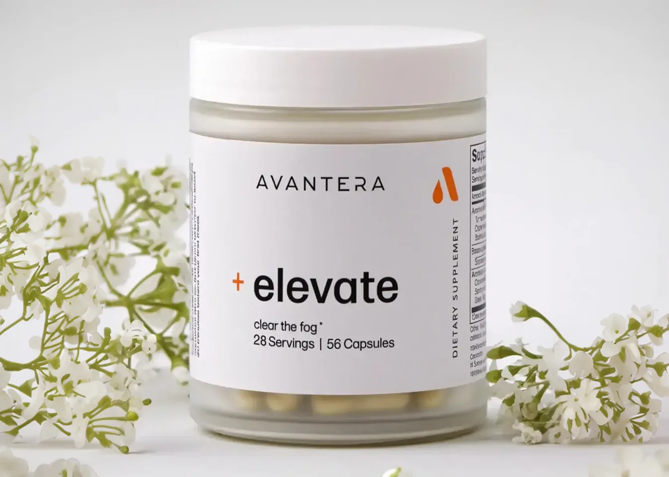 A jar of Avantera Elevate dietary supplement capsules sits on a white surface surrounded by small white flowers.