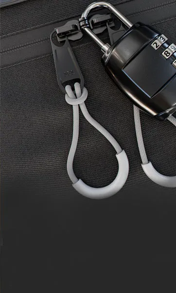 Close-up of a combination lock on a black fabric bag.