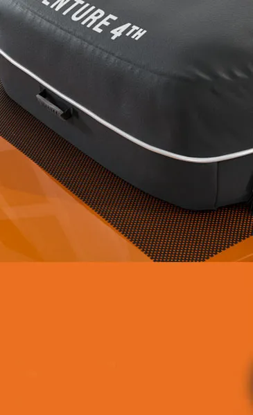 Black bag with 'ADVENTURE 4TH' text on an orange surface.